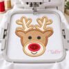 Boy reindeer applique centered on white fabric in a straight plastic embroidery machine hoop.