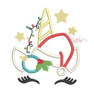 Christmas Unicorn Applique machine embroidery design featuring a Santa hat, gold unicorn horn, Christmas lights, holly, and ornament on a folded white children's top.