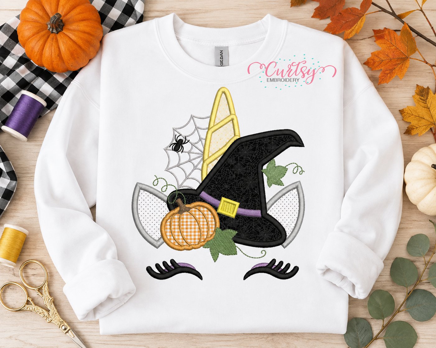 Halloween unicorn applique embroidery design on a white sweatshirt