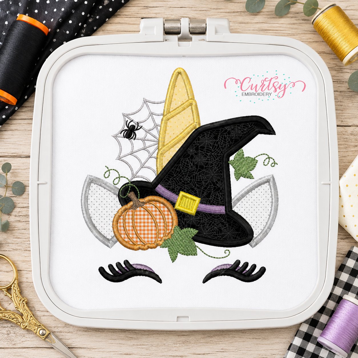 Halloween unicorn applique design stitched in a plastic machine embroidery hoop