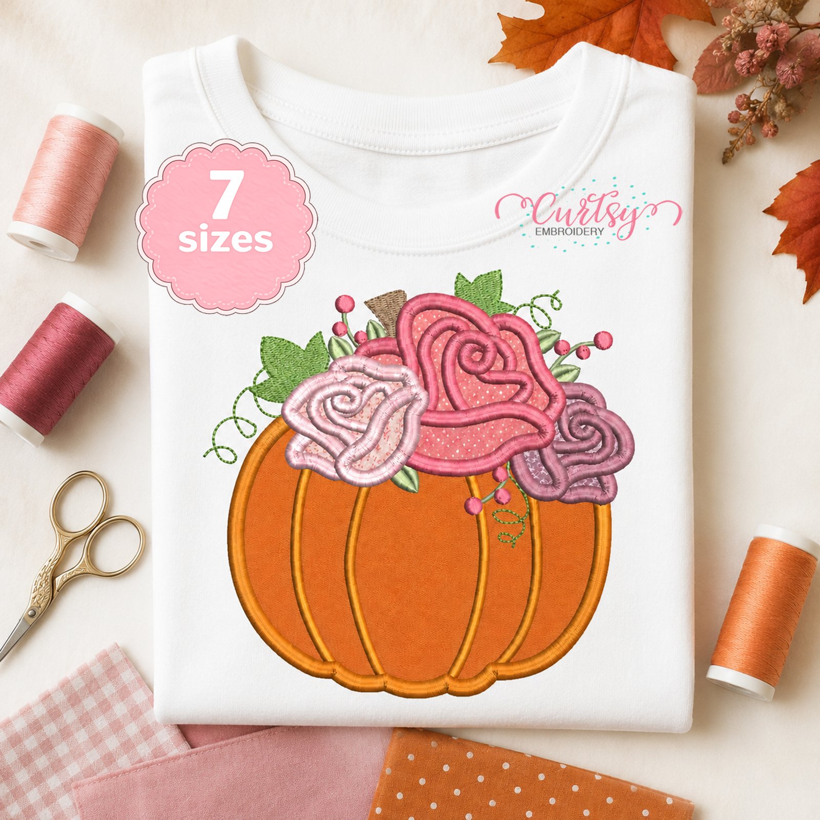 Pumpkin with Roses applique embroidery design displayed on a folded white shirt