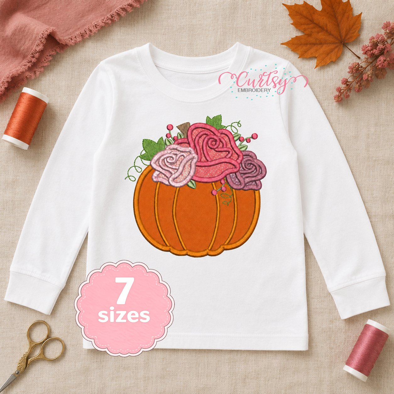 Floral pumpkin applique embroidery design on an open white long-sleeve shirt