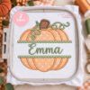 Split pumpkin monogram applique design displayed in plastic machine embroidery hoop