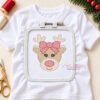White shirt extending around a rectangular plastic embroidery hoop, with the pink-bow girl reindeer centered inside the hoop.