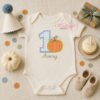 1st Birthday Pumpkin Applique Embroidery Design _ Logo 1 First birthday pumpkin applique embroidery design displayed on a folded white bodysuit