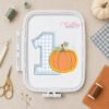 1st Birthday Pumpkin Applique Embroidery Design _ Logo 2 Number one pumpkin applique design displayed in a plastic machine embroidery hoop