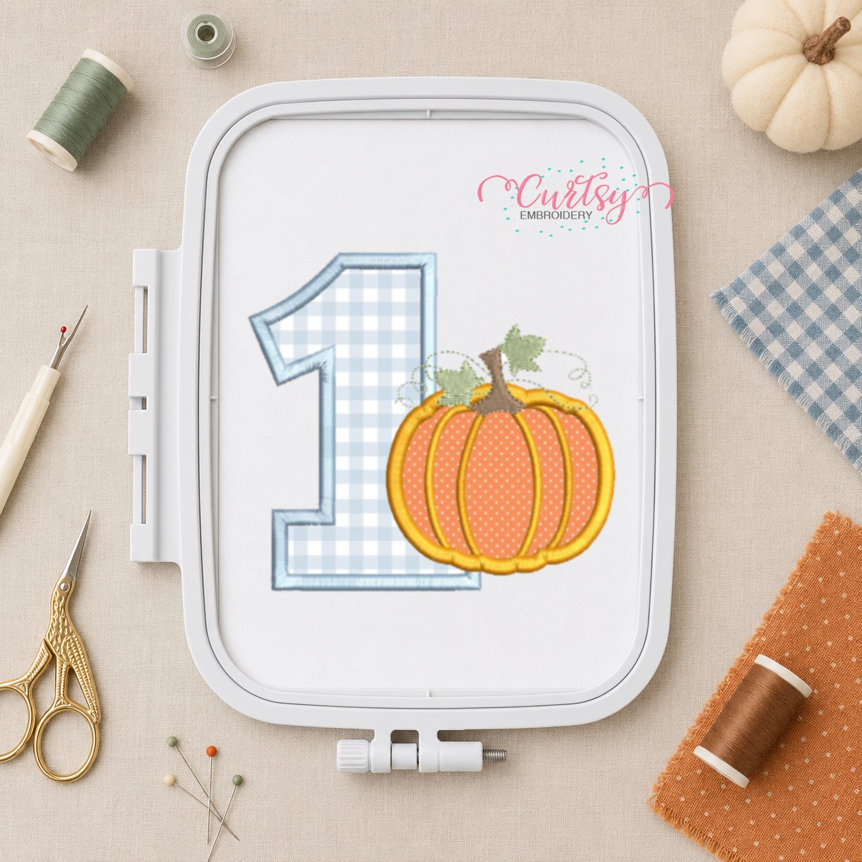 Number one pumpkin applique design displayed in a plastic machine embroidery hoop