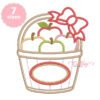 Apple basket with bow applique embroidery design stitched on a folded white shirt