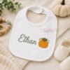 Mini pumpkin embroidery design stitched on a personalized baby bib