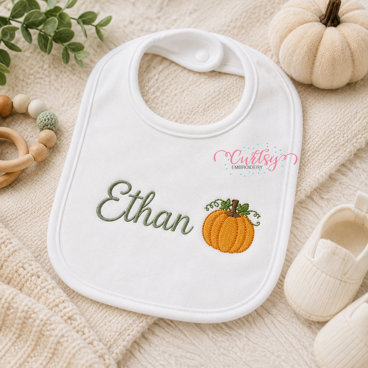 Mini pumpkin embroidery design stitched on a personalized baby bib