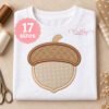 Acorn applique embroidery design stitched on a folded white shirt