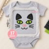 Cat face applique embroidery design stitched on gray fabric in a plastic embroidery machine hoop