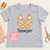 Personalized Jack O Lantern applique design with Sawyer embroidered below on an open gray shirt