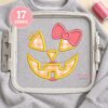 Girl jack o lantern applique on a gray sweatshirt secured inside a rectangular plastic embroidery machine hoop
