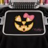 Girl jack o lantern applique stitched on a properly hooped black sweatshirt inside a multi-needle embroidery machine