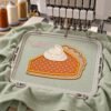 Pumpkin pie applique in a plastic hoop attached to an embroidery machine