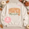 Pumpkin Season machine embroidery design displayed on a cream sweatshirt in a styled autumn flat lay