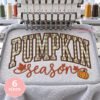Pumpkin Season applique embroidery design being stitched in a multi-needle embroidery machine