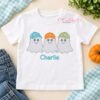 Boy Ghosts with Baseball Hats Quick Stitch Embroidery Design _ Logo 3 White shirt with three ghosts in colorful baseball hats and the name Charlie embroidered below in aqua, beside denim and a pumpkin.