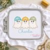Boy Ghosts with Hats Trio Applique Design _ Logo 2 White shirt in a rectangular plastic embroidery machine hoop with a baseball hat ghost trio applique and Charlie stitched in aqua beneath the design.