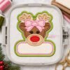 Girl Reindeer Ornament Applique Design _ Etsy 2000 Girl reindeer applique ornament with a pink bow and blank name panel stitched on stabilizer in a plastic embroidery machine hoop, surrounded by thread, fabric, and scissors.