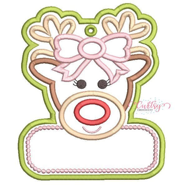 Girl Reindeer Ornament Applique Design _ Website Girl reindeer ornament applique embroidery design with a bow, eyelashes, red nose, stitched hanging eyelet, and blank personalization panel bordered by pink dots.